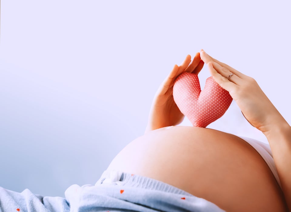 A heart on top of a pregnant belly
