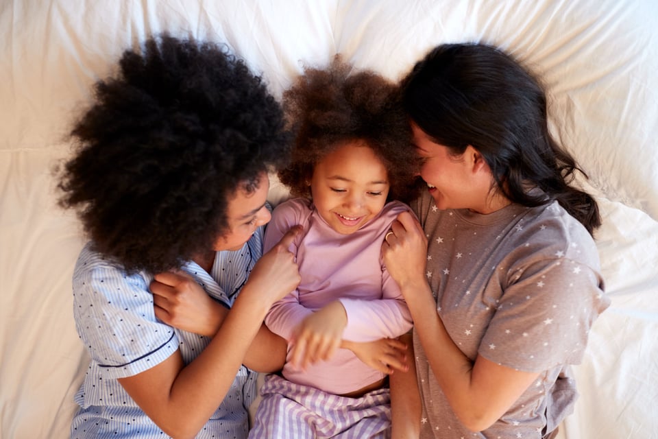 Gay couple in bed with a daughter