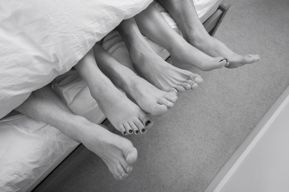 Feet in bed as a sign of threesome