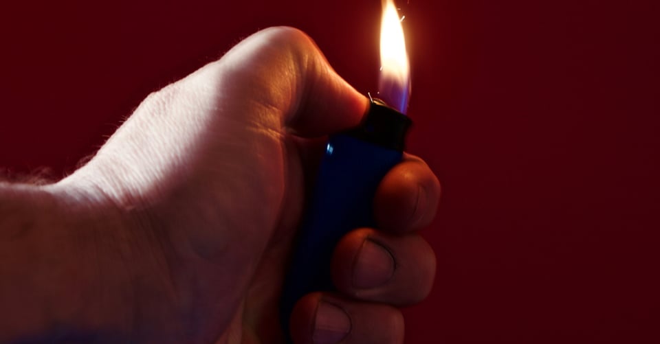 A delinquent hand holding a lighter