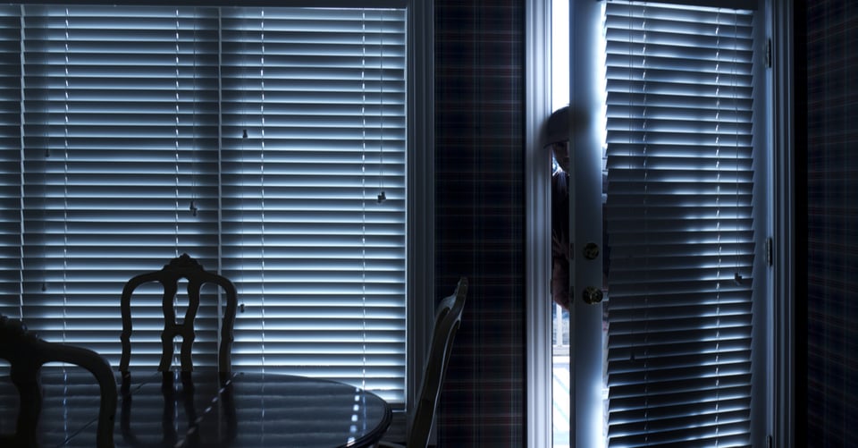 Man slowly entering a house