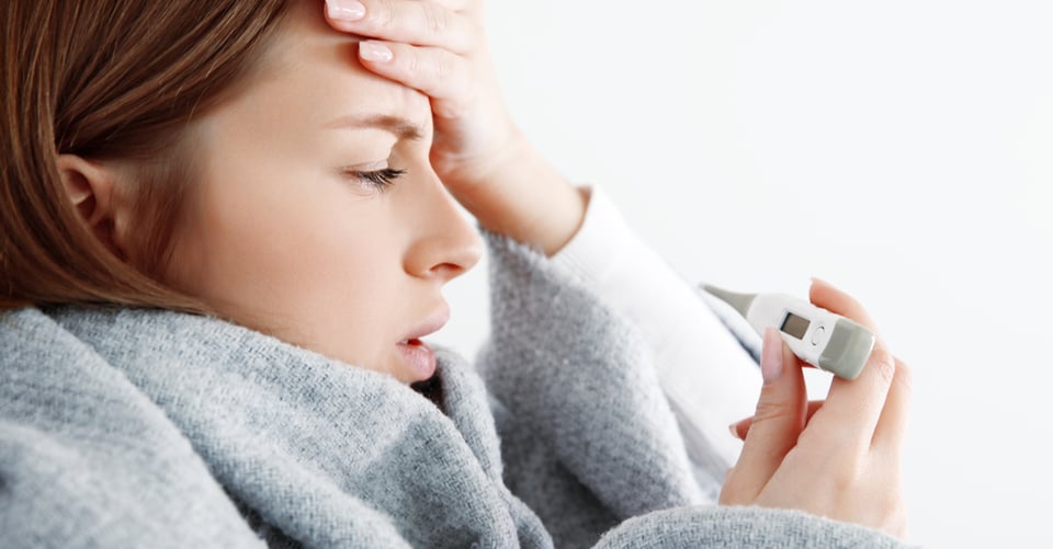 Mujer con fiebre, que es uno de los síntomas de virus