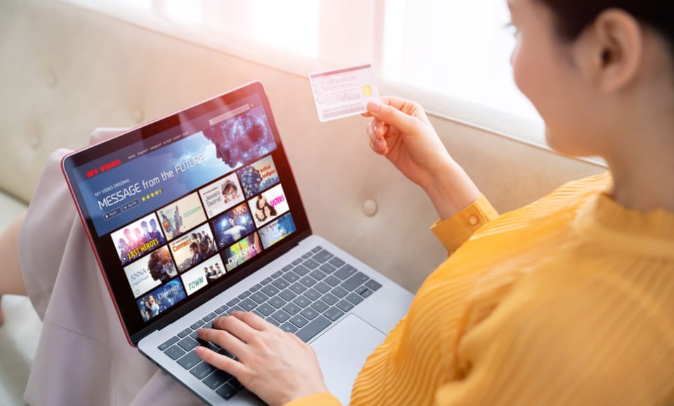 woman with computer, woman with credit card, streaming services, television packages, MundoNOW