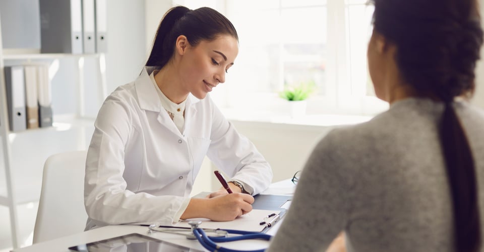Mujer consultando con médico por embarazo