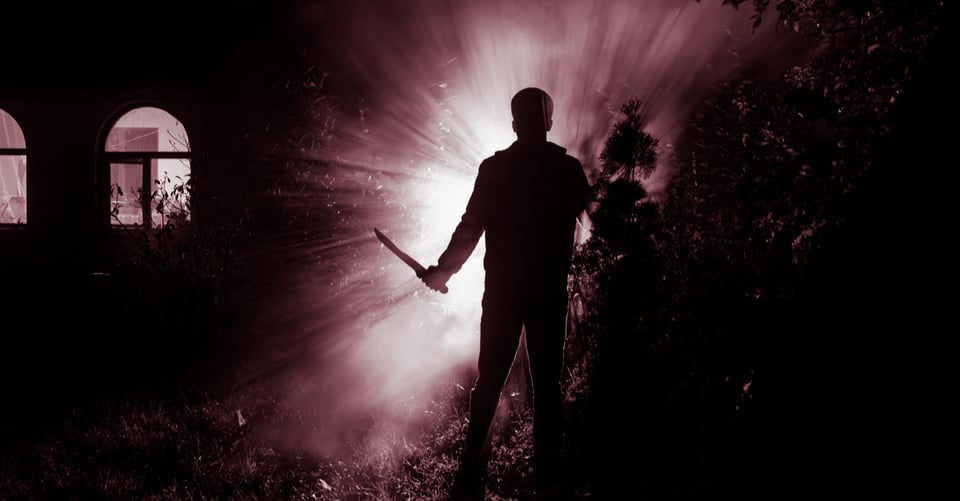 Man with knife in hand outside a house