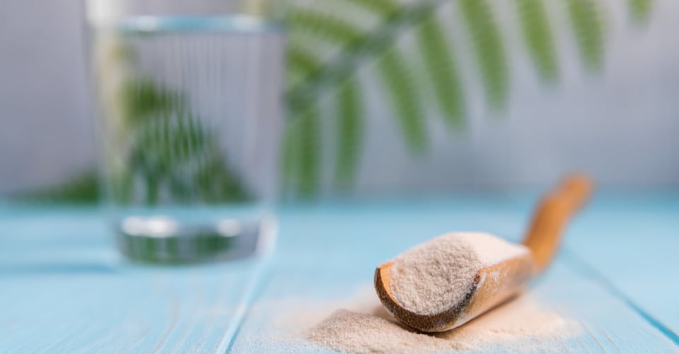 Cuchara de madera con polvo que pudiera ser colágeno